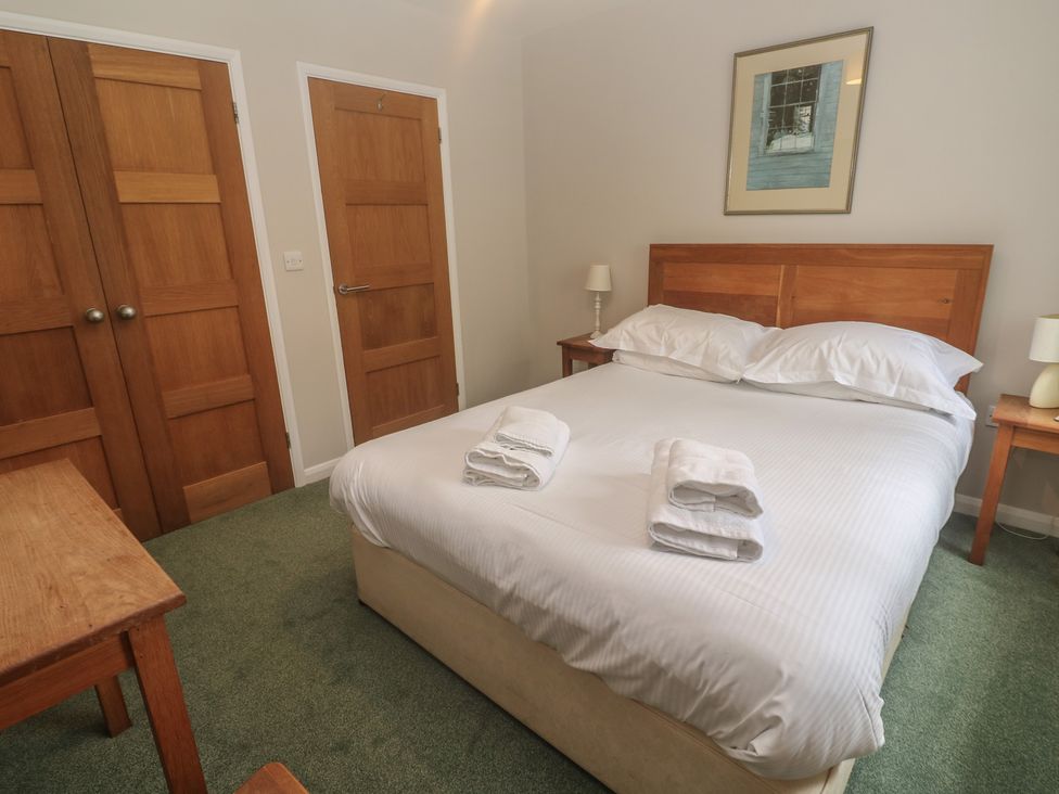 A bedroom with a bed and bedside tables at The Meadow in Feock near Carnon Downs
