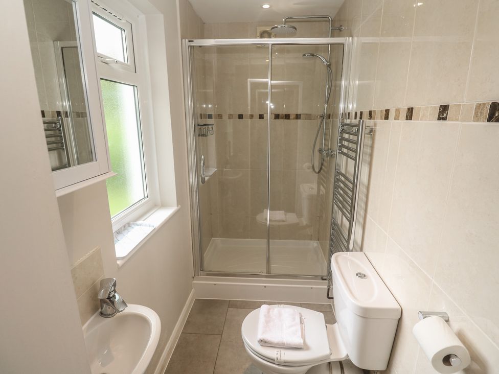 A bathroom with a shower, sink, and toilet at The Meadow in Feock near Carnon Downs