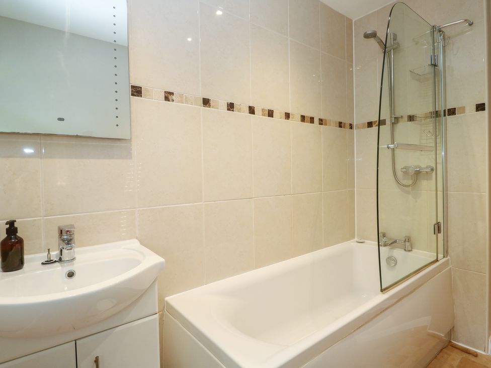 A bathroom with a bathtub and sink at The Meadow in Feock near Carnon Downs