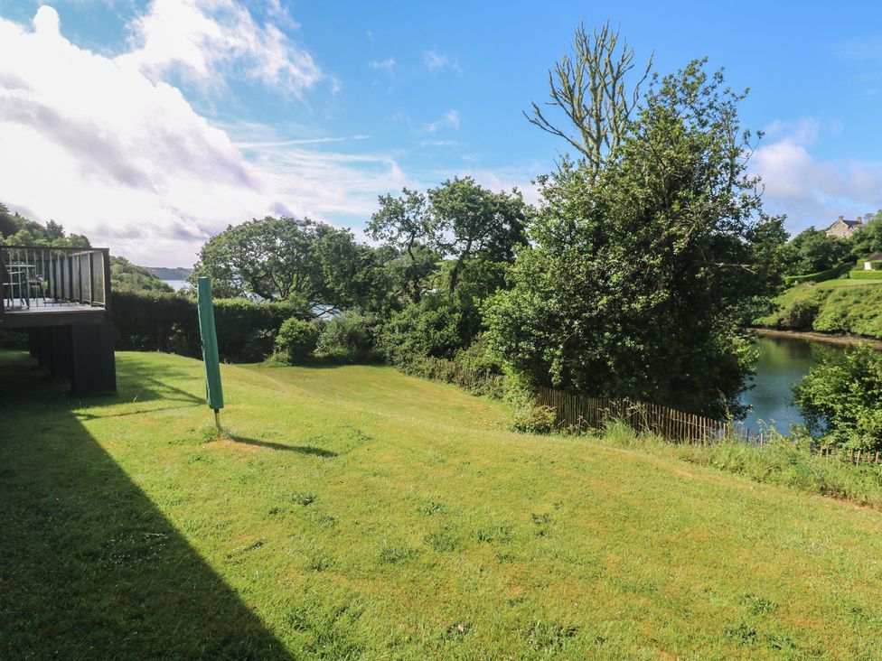 A garden with grass and trees near a river at The Meadow in Feock near Carnon Downs
