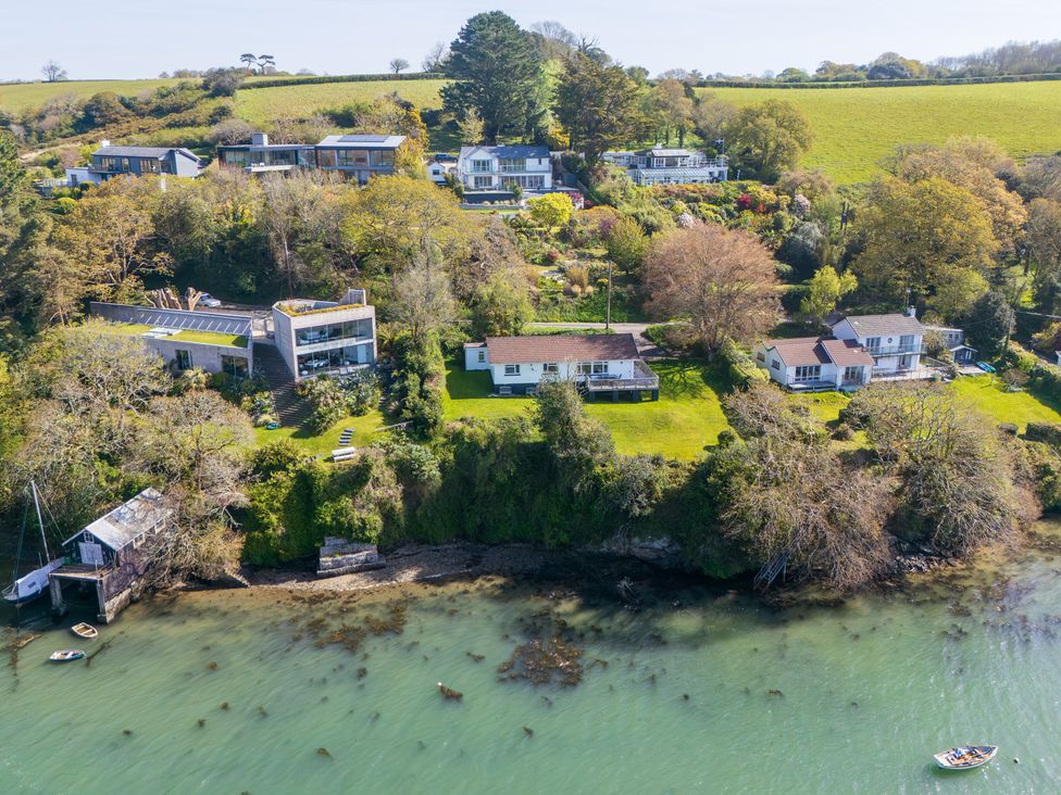 A view of several homes and gardens by the water at The Meadow in Feock near Carnon Downs