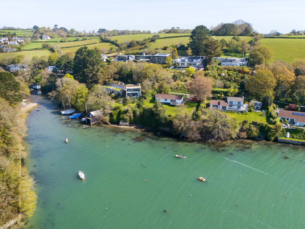 A river with boats and houses along the banks at The Meadow in Feock near Carnon Downs
