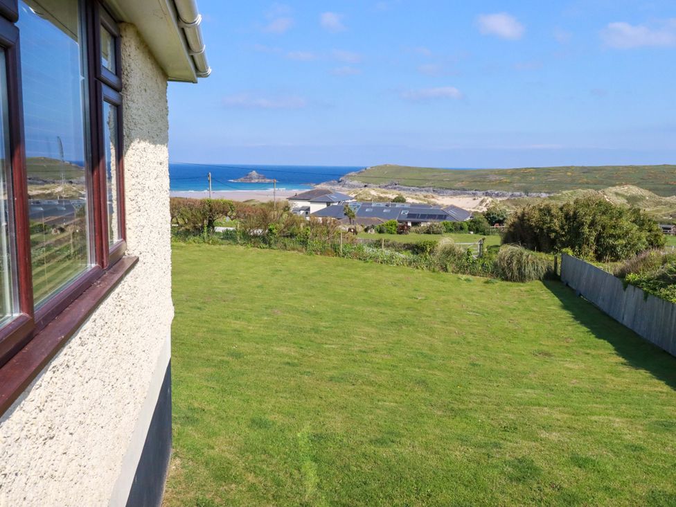A view of the sea and houses from a garden at Pentreath in Crantock