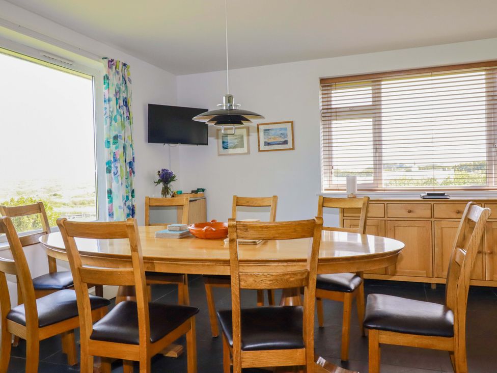 A dining room with a table and chairs at Pentreath in Crantock