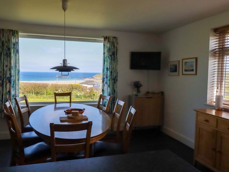 A dining room with a round table and sea view at Pentreath in Crantock