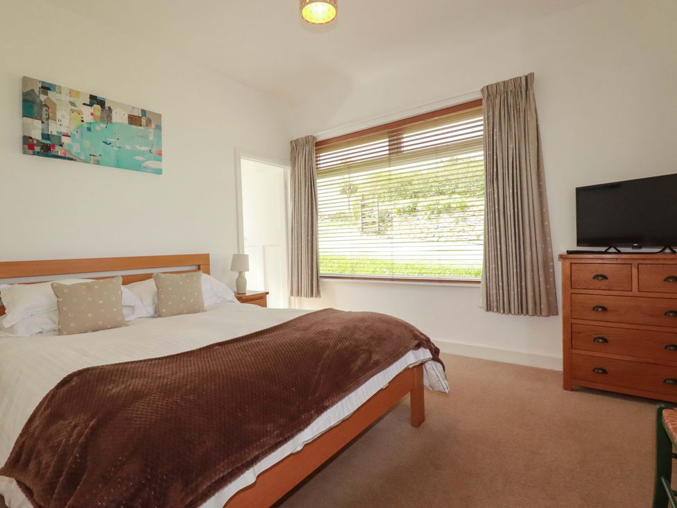 A bedroom with a bed and television at Pentreath in Crantock