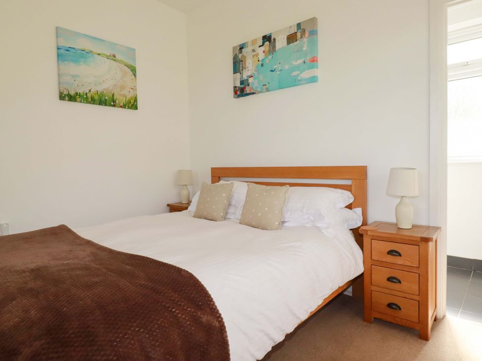 A bedroom with a bed and bedside tables at Pentreath in Crantock