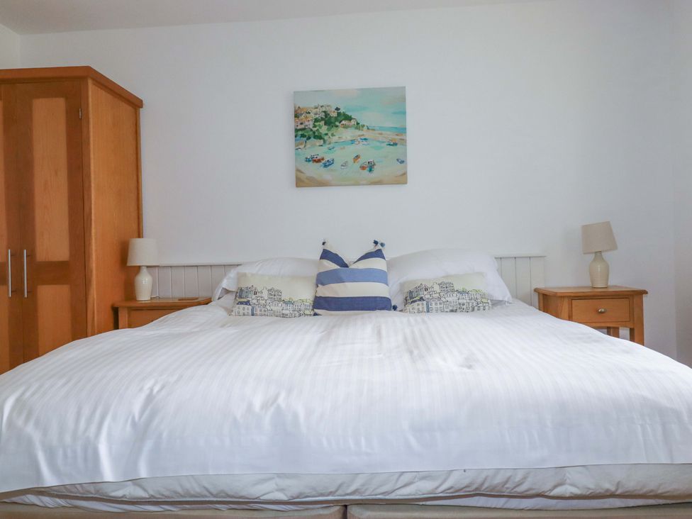 A bedroom with a large bed and nightstands at Pentreath in Crantock