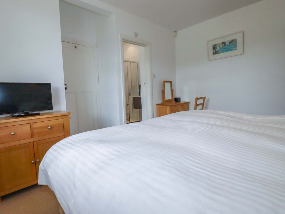 A bedroom with a bed and television at Pentreath in Crantock