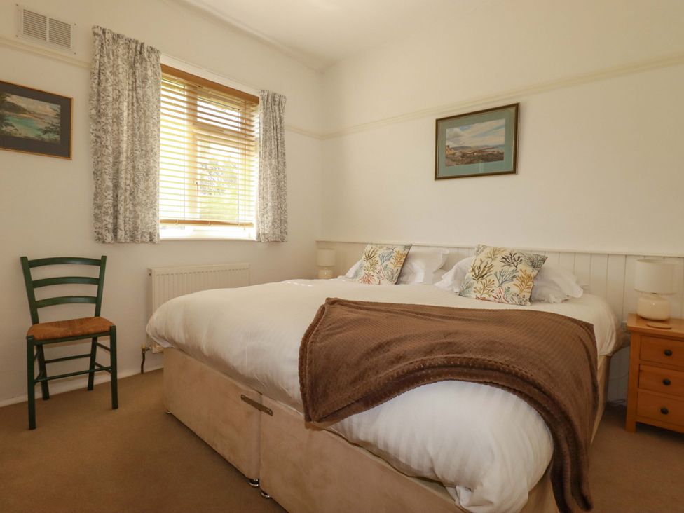 A bedroom with a double bed and a chair at Pentreath in Crantock