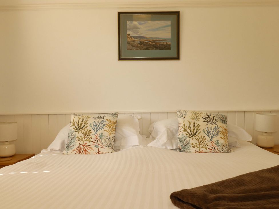 A bedroom with a bed and decorative pillows at Pentreath in Crantock