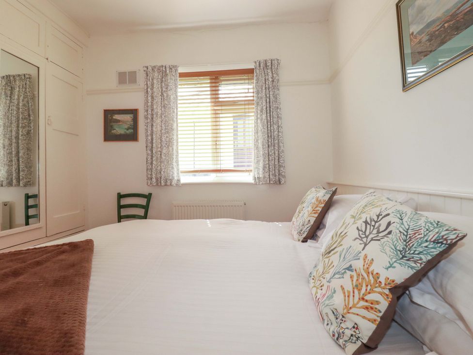 A bedroom with a bed and window at Pentreath in Crantock