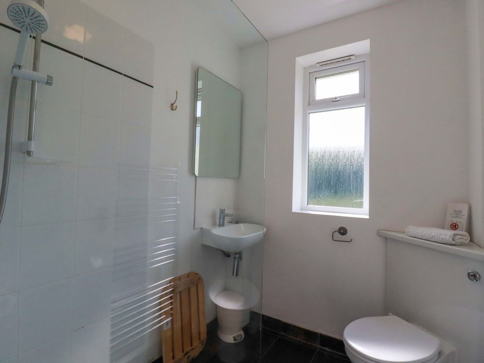A bathroom with a shower, sink, and toilet at Pentreath in Crantock