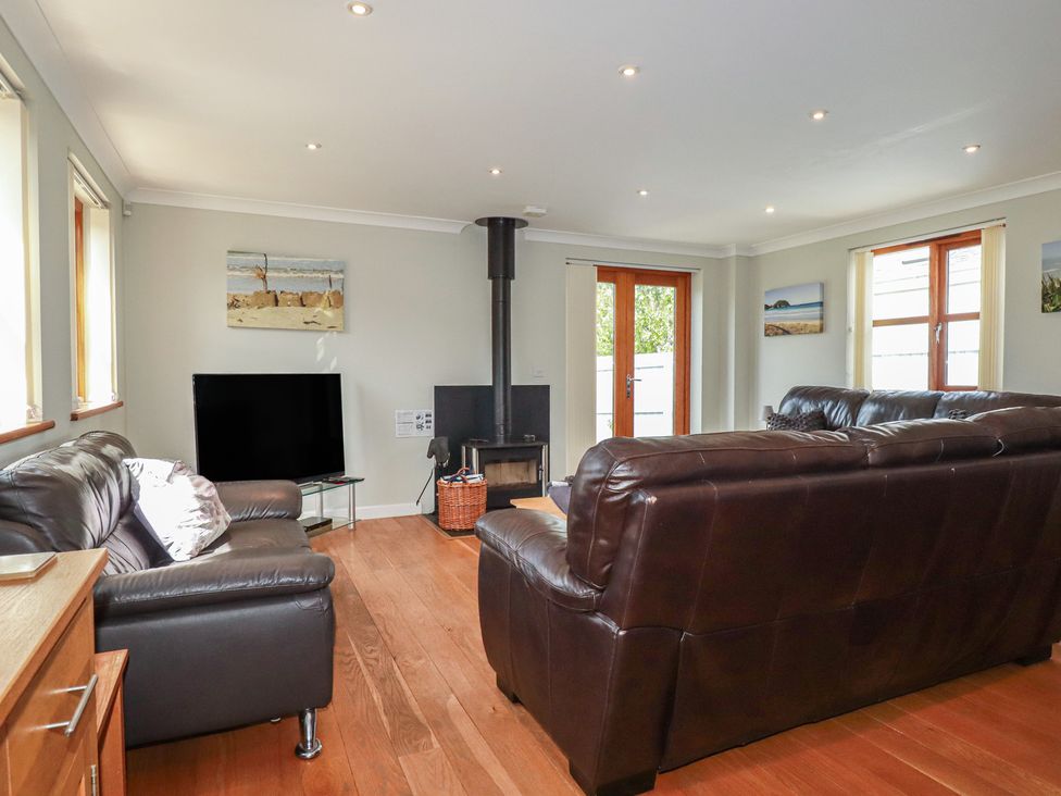 A living room with a television and a wood stove at Carpe Diem in Crantock