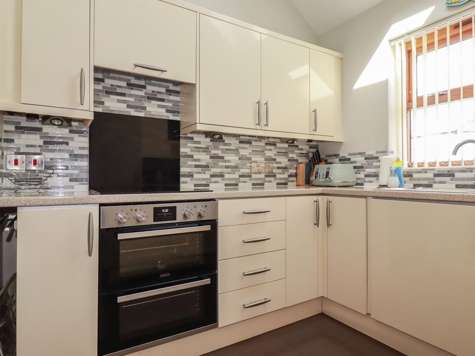 A kitchen with cabinets, oven, sink and countertop at Carpe Diem in Crantock