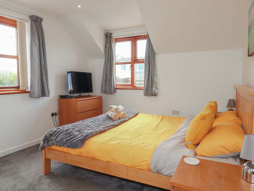A bedroom with a bed and television at Carpe Diem in Crantock