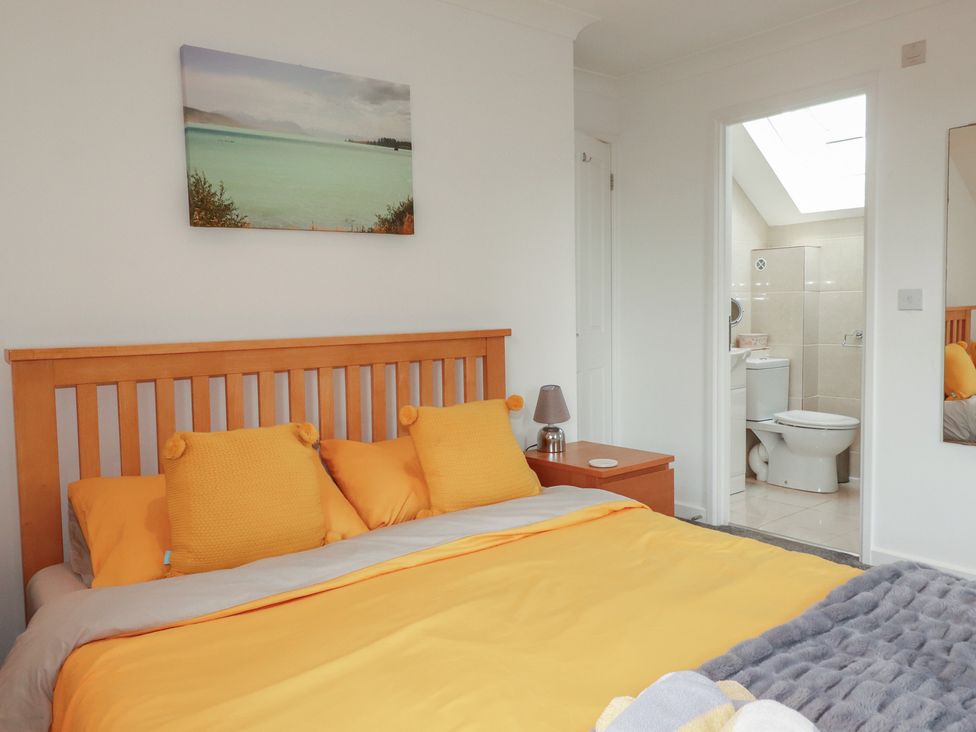 A bedroom with a bed and adjoining bathroom at Carpe Diem in Crantock