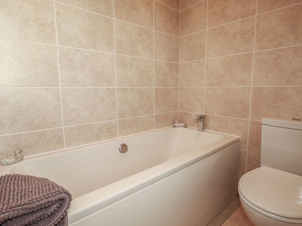 A bathroom with a bathtub and a toilet at Carpe Diem in Crantock