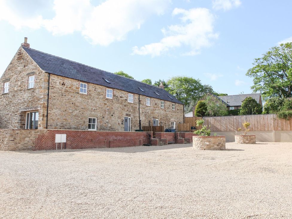 An outdoor area with a stone building and gravel surface at The Turnip Barn in 