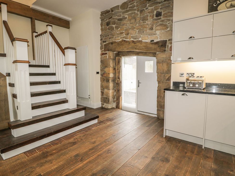 An entryway with a staircase and kitchen cabinets at The Turnip Barn in 