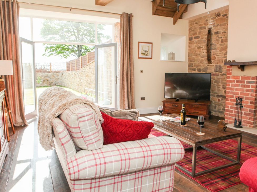 A living room with a sofa and television at The Turnip Barn in 