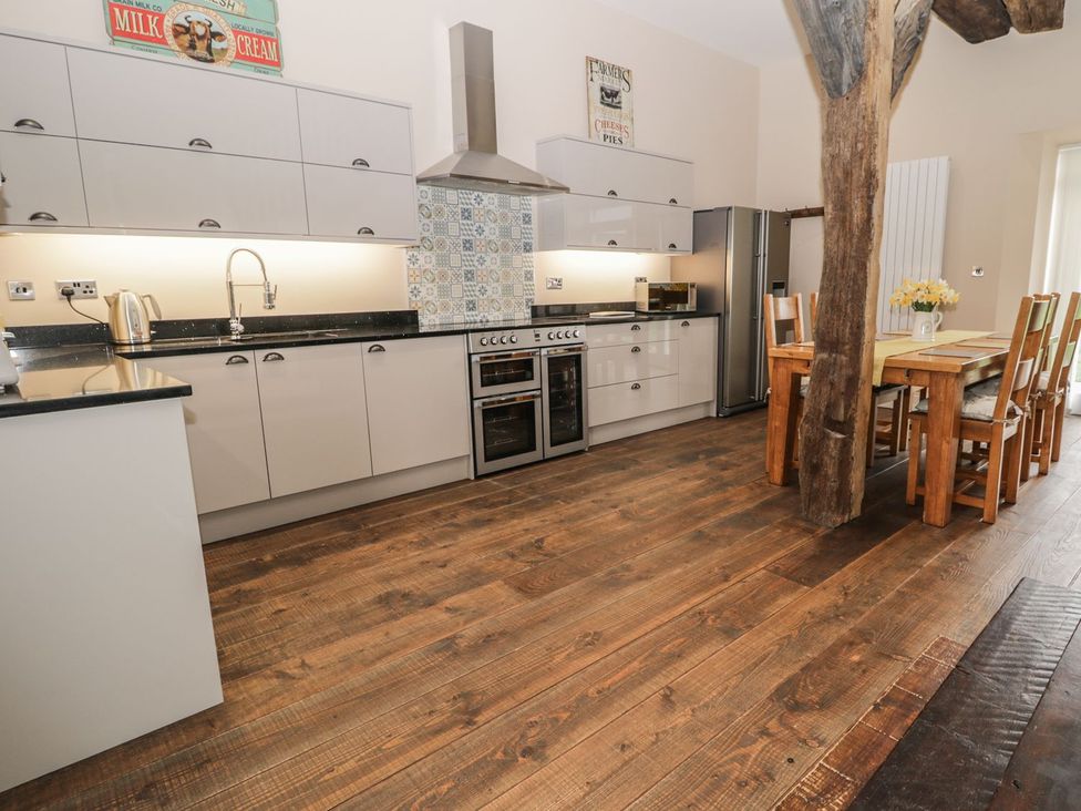 A kitchen with cabinets and a dining table at The Turnip Barn in 