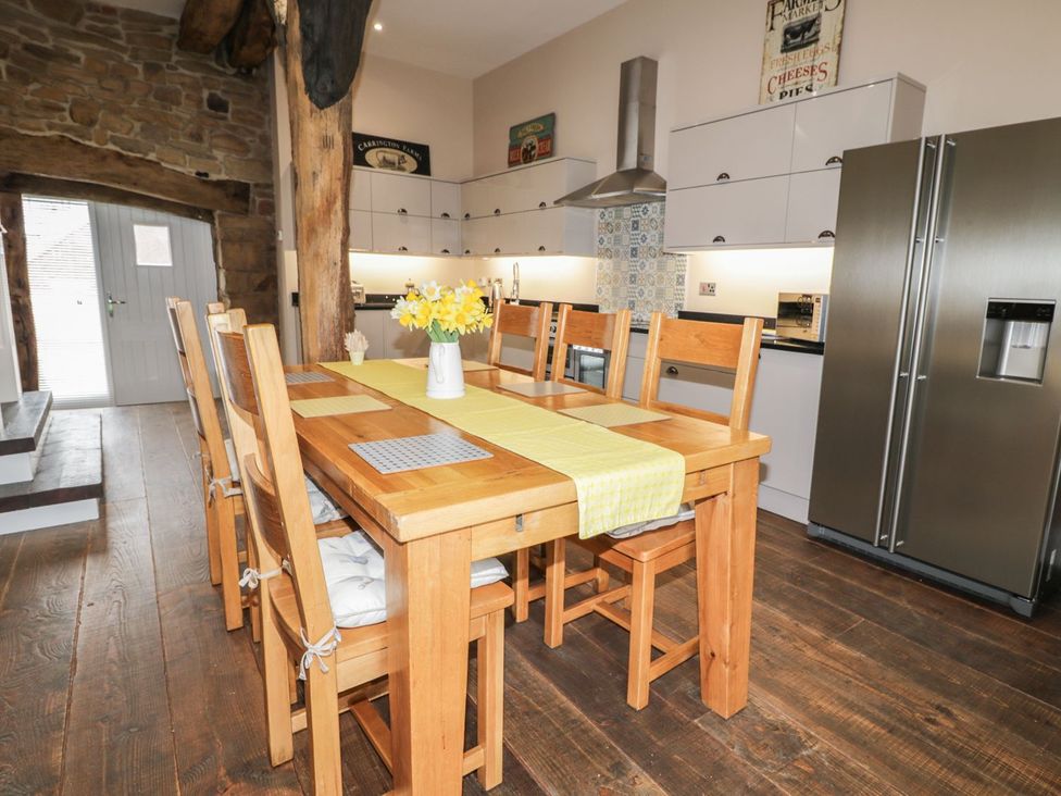 A kitchen with a dining table and refrigerator at The Turnip Barn