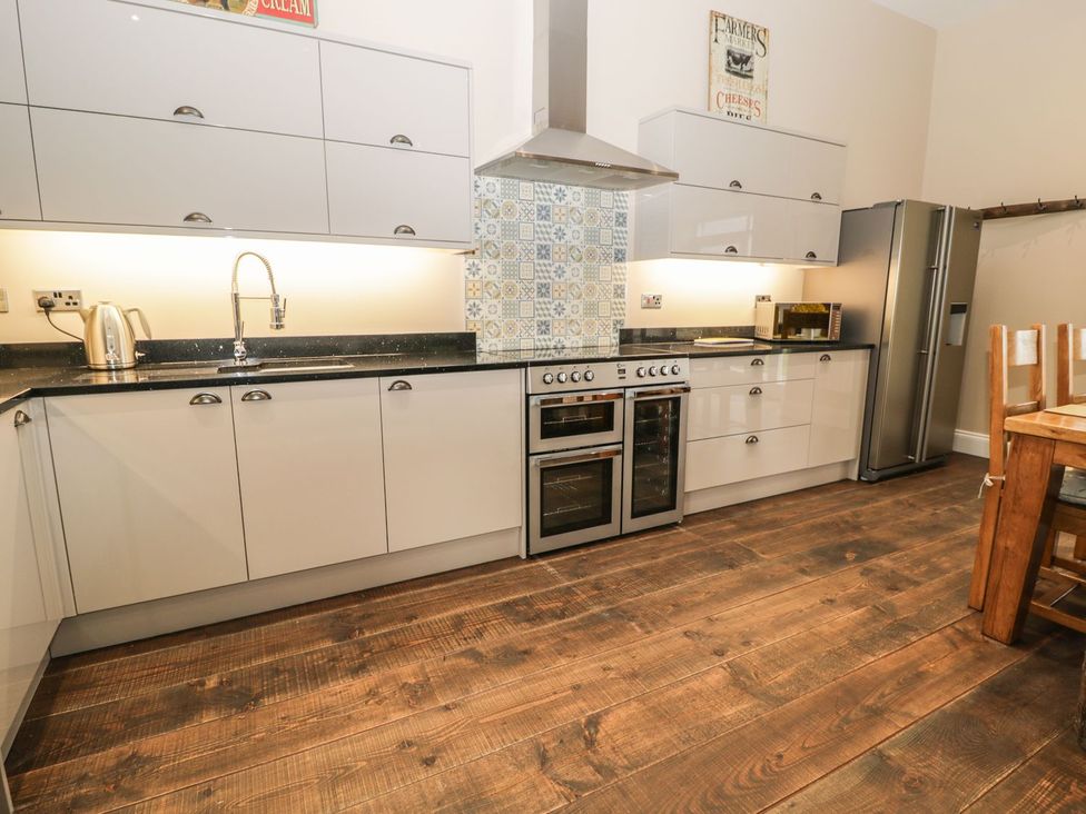 A kitchen with cabinets, sink, kettle, cooker and refrigerator at The Turnip Barn in 