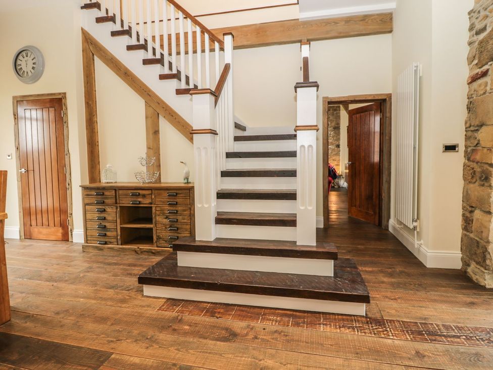 A staircase and console table in a hallway at The Turnip Barn in 