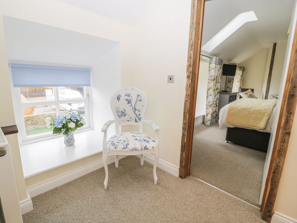 A bedroom with a window and chair at The Turnip Barn