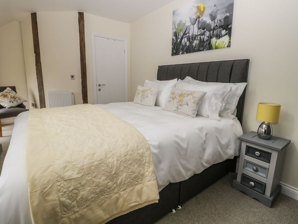 A bedroom with a bed and nightstand at The Turnip Barn in 