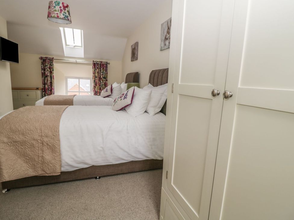 A bedroom with two beds and a wardrobe at The Turnip Barn