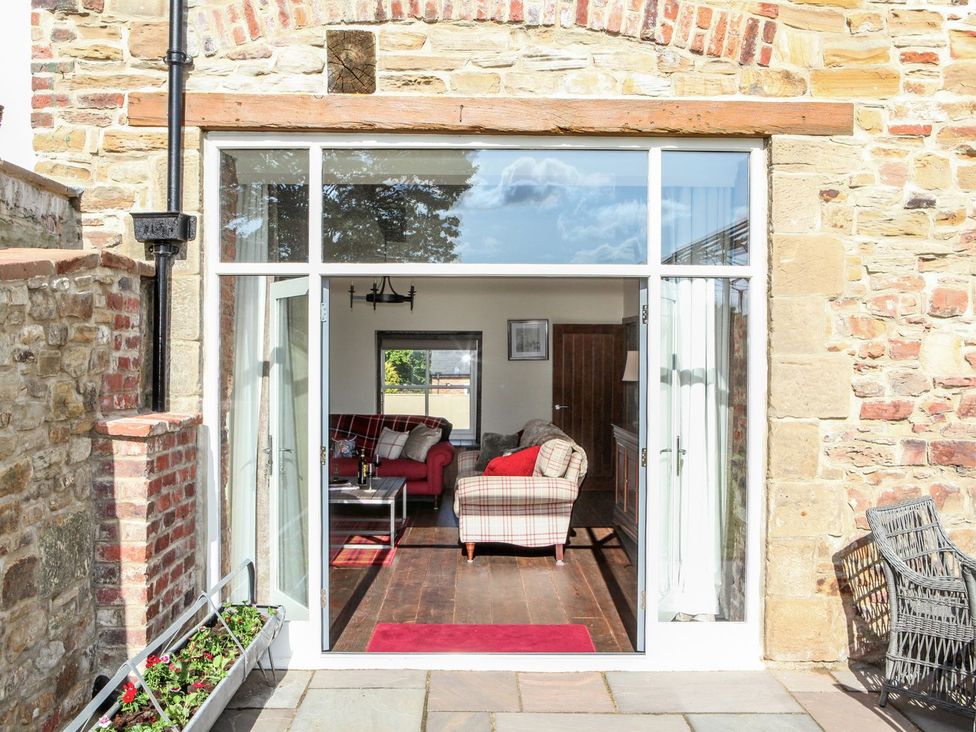 A living room with a sofa and coffee table visible from outside at The Turnip Barn in 