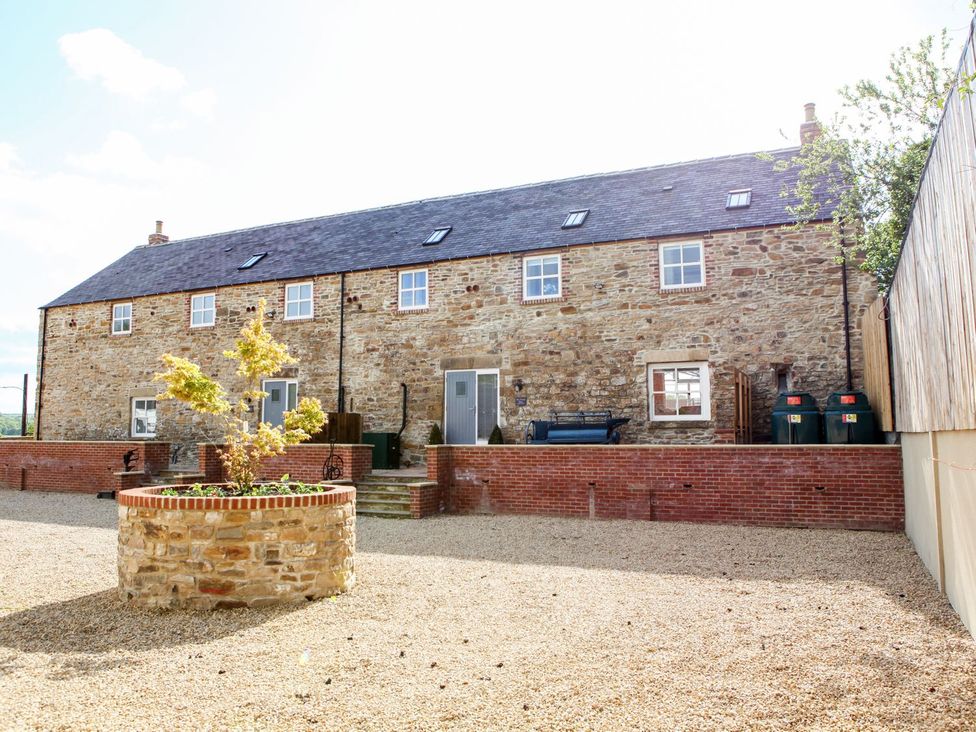 A stone building with windows and a planter in an outdoor area at The Turnip Barn