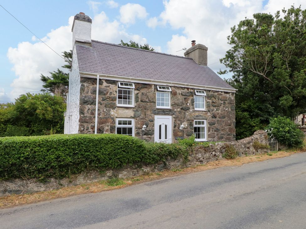 A house with a stone exterior and windows at Tan Y Goeden Morfa Nefyn