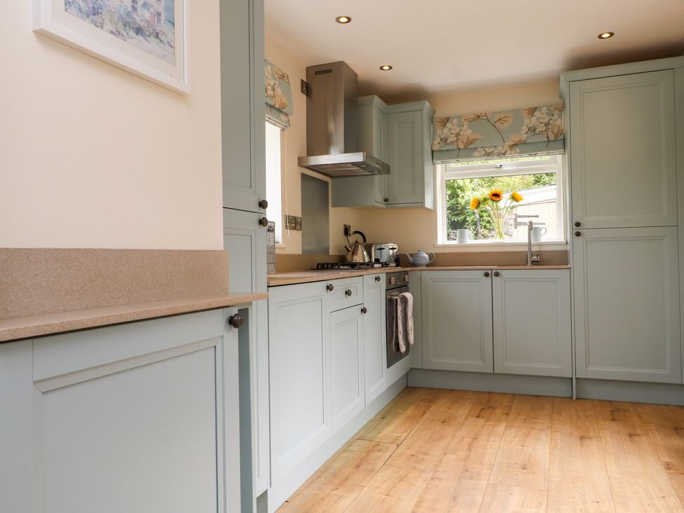 A kitchen with cabinets and a sink at Tan Y Goeden Morfa Nefyn