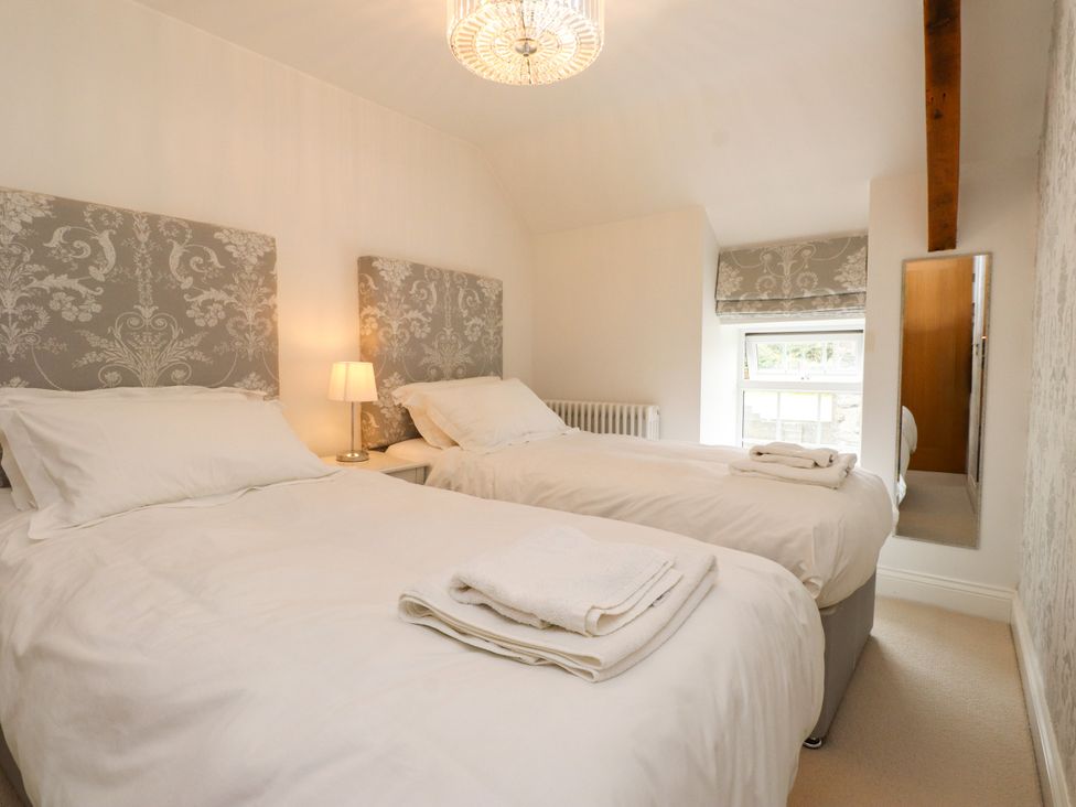 A bedroom with two beds and a nightstand at Tan Y Goeden in Morfa Nefyn