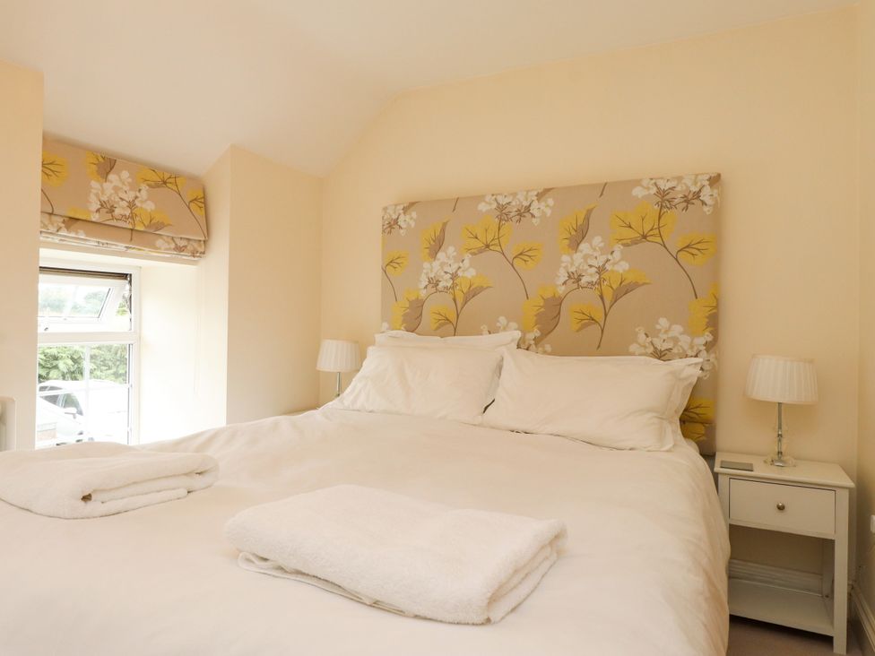 A bedroom with a bed and nightstand at Tan Y Goeden Morfa Nefyn