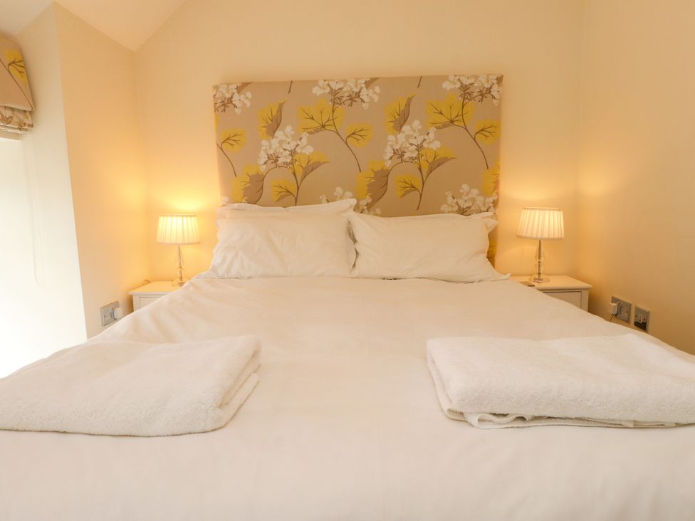 A bedroom with a double bed and bedside lamps at Tan Y Goeden in Morfa Nefyn