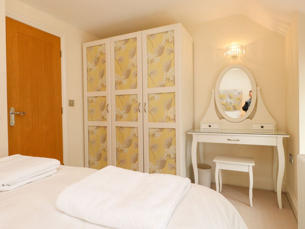 A bedroom with a wardrobe and dressing table at Tan Y Goeden in Morfa Nefyn