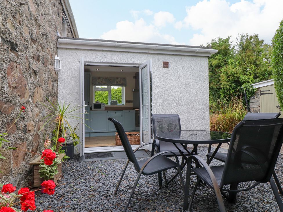 An outdoor seating area with a table and chairs at Tan Y Goeden Morfa Nefyn