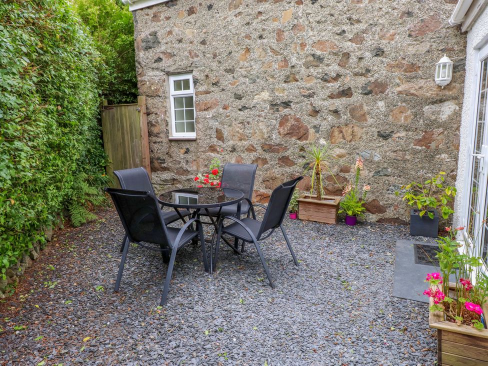 A garden with a table and chairs at Tan Y Goeden in Morfa Nefyn