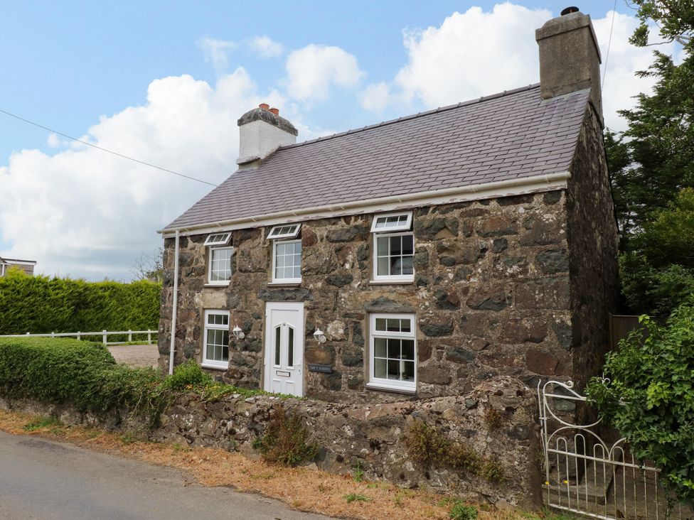 A house with stone exterior and windows at Tan Y Goeden in Morfa Nefyn