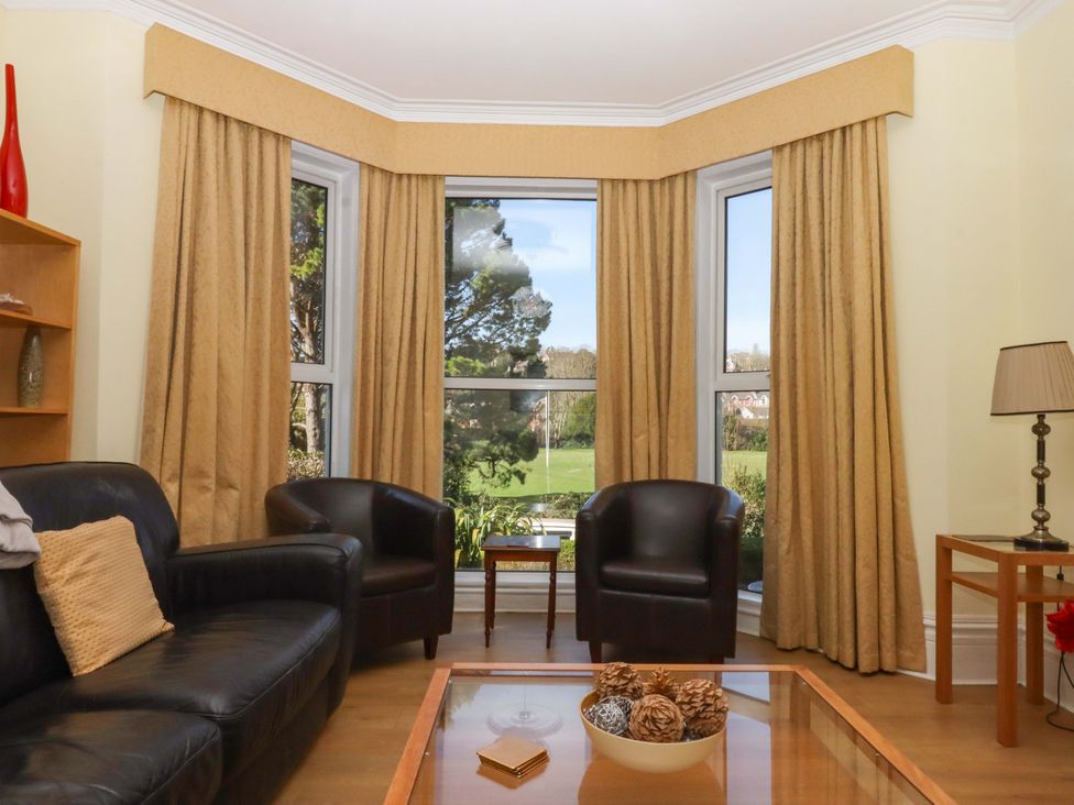 A living room with a sofa, chairs, and a coffee table at Avenue Park Villa in Torquay