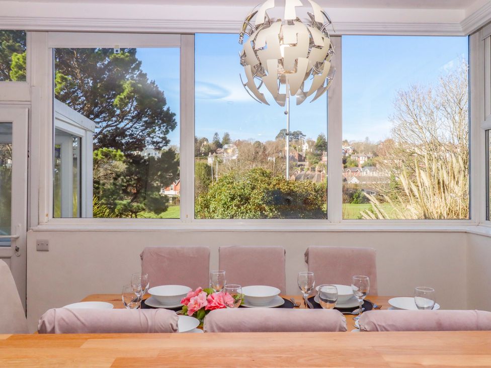 A dining table with tableware and flowers at Avenue Park Villa in Torquay