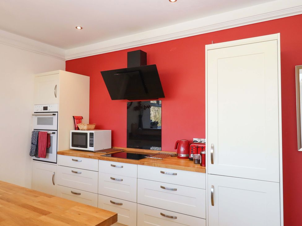 A kitchen with appliances and cabinets at Avenue Park Villa in Torquay