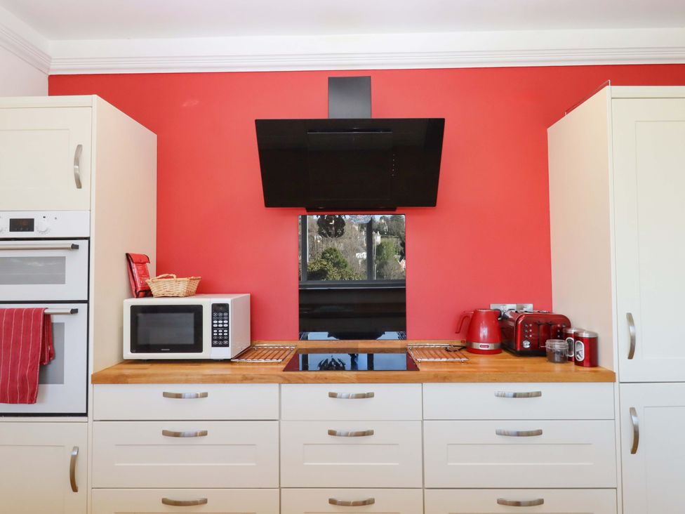 A kitchen with appliances and cabinets at Avenue Park Villa in Torquay