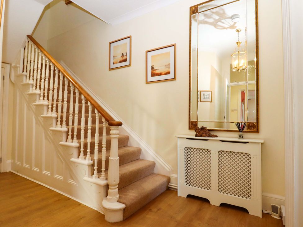A hallway with a staircase and mirror at Avenue Park Villa in Torquay