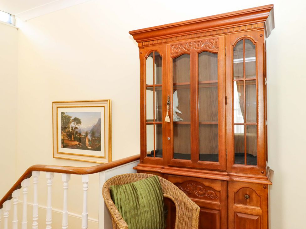 A hallway with a cabinet and a painting at Avenue Park Villa in Torquay