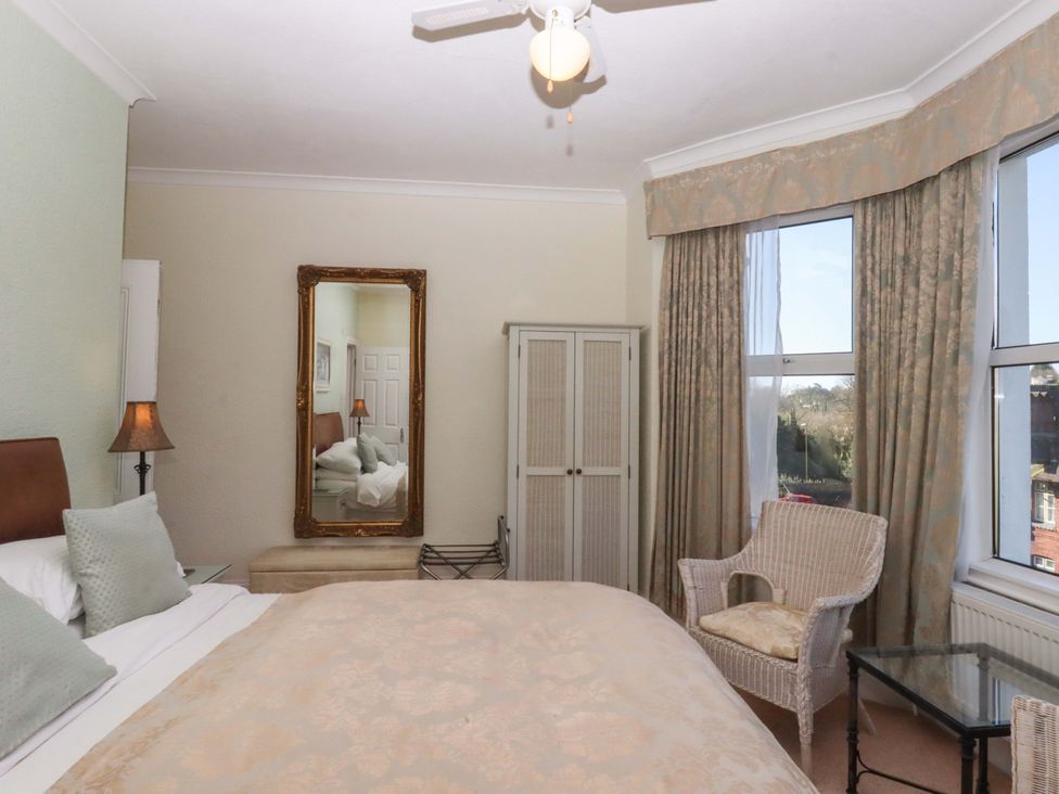 A bedroom with a bed and chair at Avenue Park Villa in Torquay